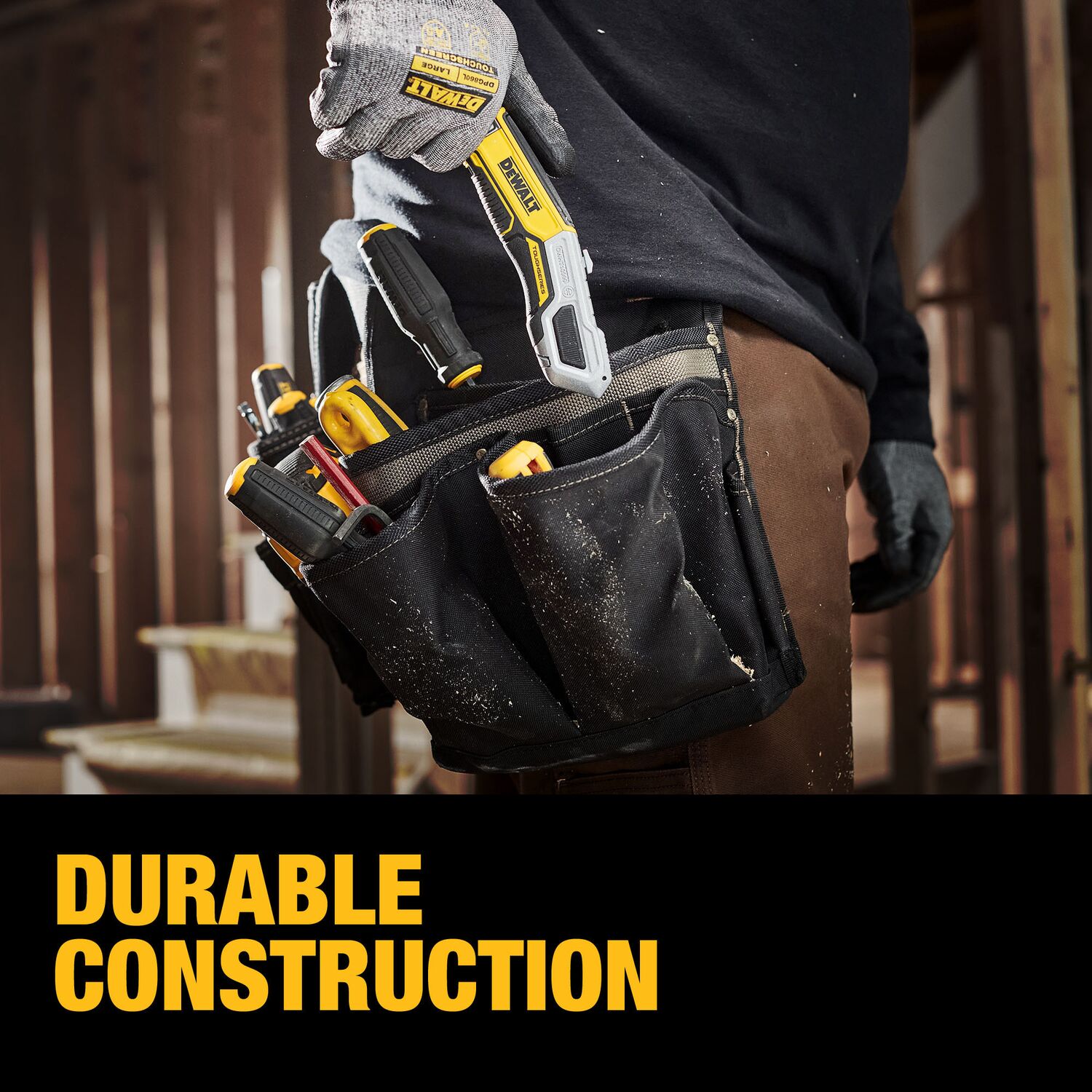 Contractor carrying the DeWalt DWHT10999 TOUGHSERIES utility knife in a tool pouch on a dusty jobsite, highlighting the knife’s durable construction.