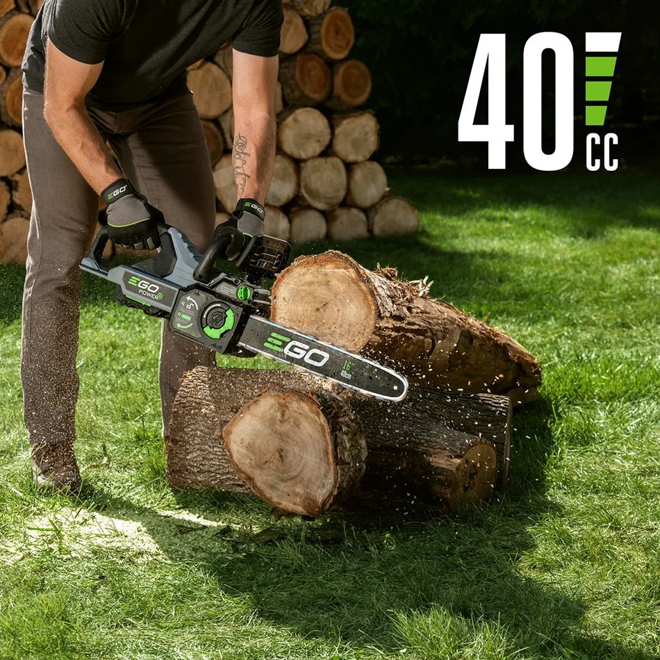 EGO CS1611 16-inch cordless chainsaw cutting stacked logs on grass, showing 40cc gas-equivalent cutting power in use