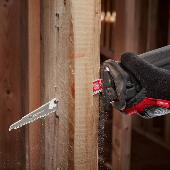 Milwaukee SAWZALL reciprocating saw cutting through wood framing with embedded nails using a carbide tooth demolition blade while wearing a Milwaukee work glove