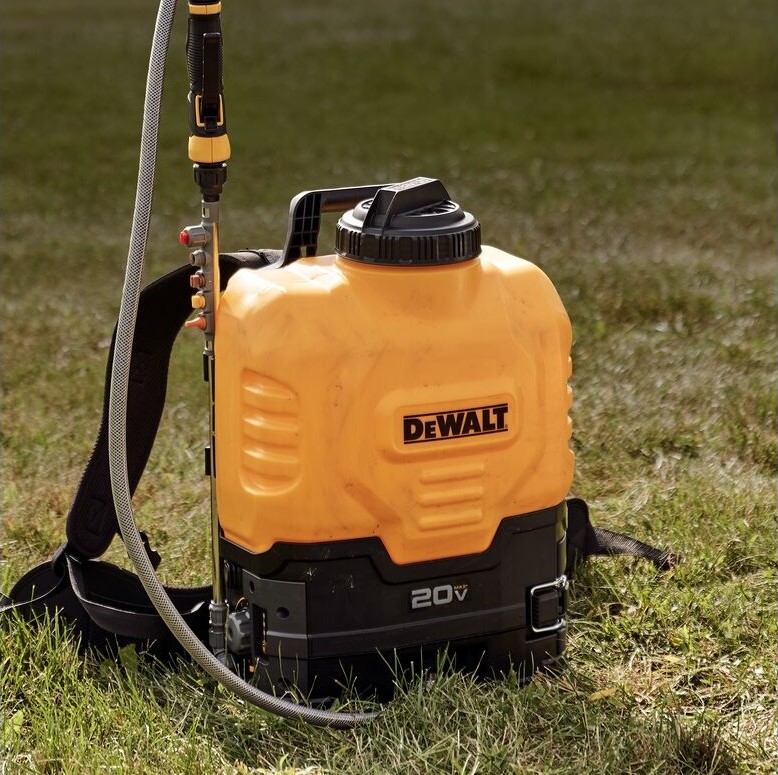 DEWALT 184766 sprayer wand and nozzle kit installed on 20V backpack sprayer, stainless steel wand and nozzle assembly attached, sprayer tank on grass with hose and shoulder straps visible, outdoor use application image