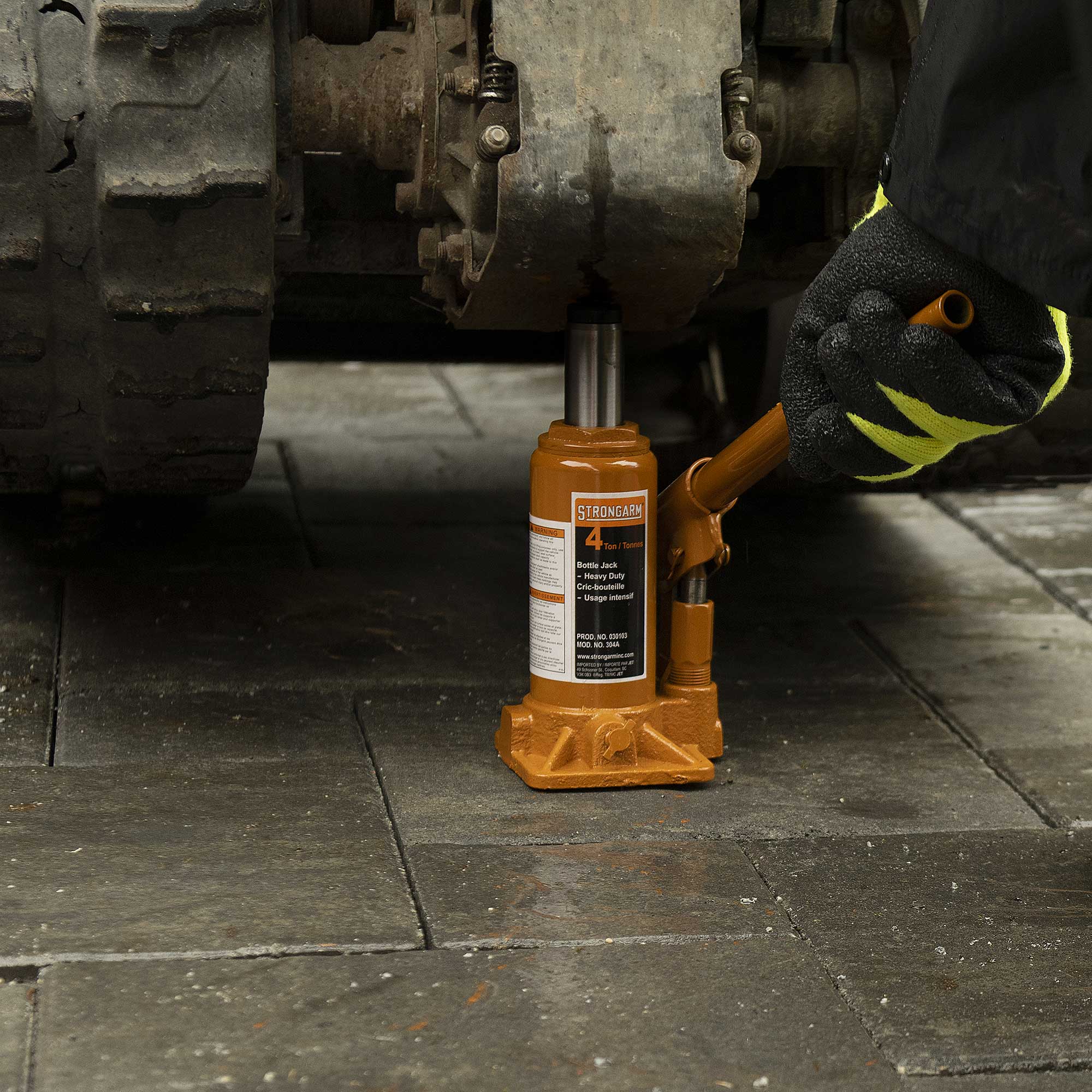 4 ton bottle jack lifting truck axle assembly during maintenance and repair work