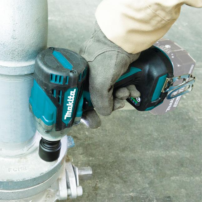 Makita DTW300XVZ 18V LXT Brushless 1/2" Impact Wrench removing or tightening fasteners on industrial piping equipment, demonstrating compact head design for access in confined maintenance and service applications.