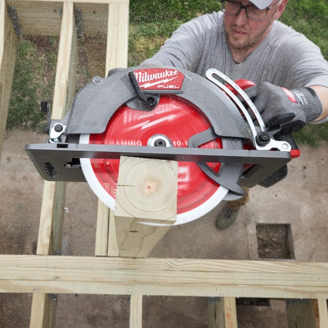 Carpenter using a Milwaukee M18 FUEL 10-1/4" rear-handle circular saw to cut through thick framing lumber in a single pass.